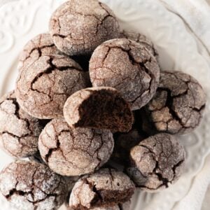 Overhead view of chocolate snowball cookies piled on a white plate
