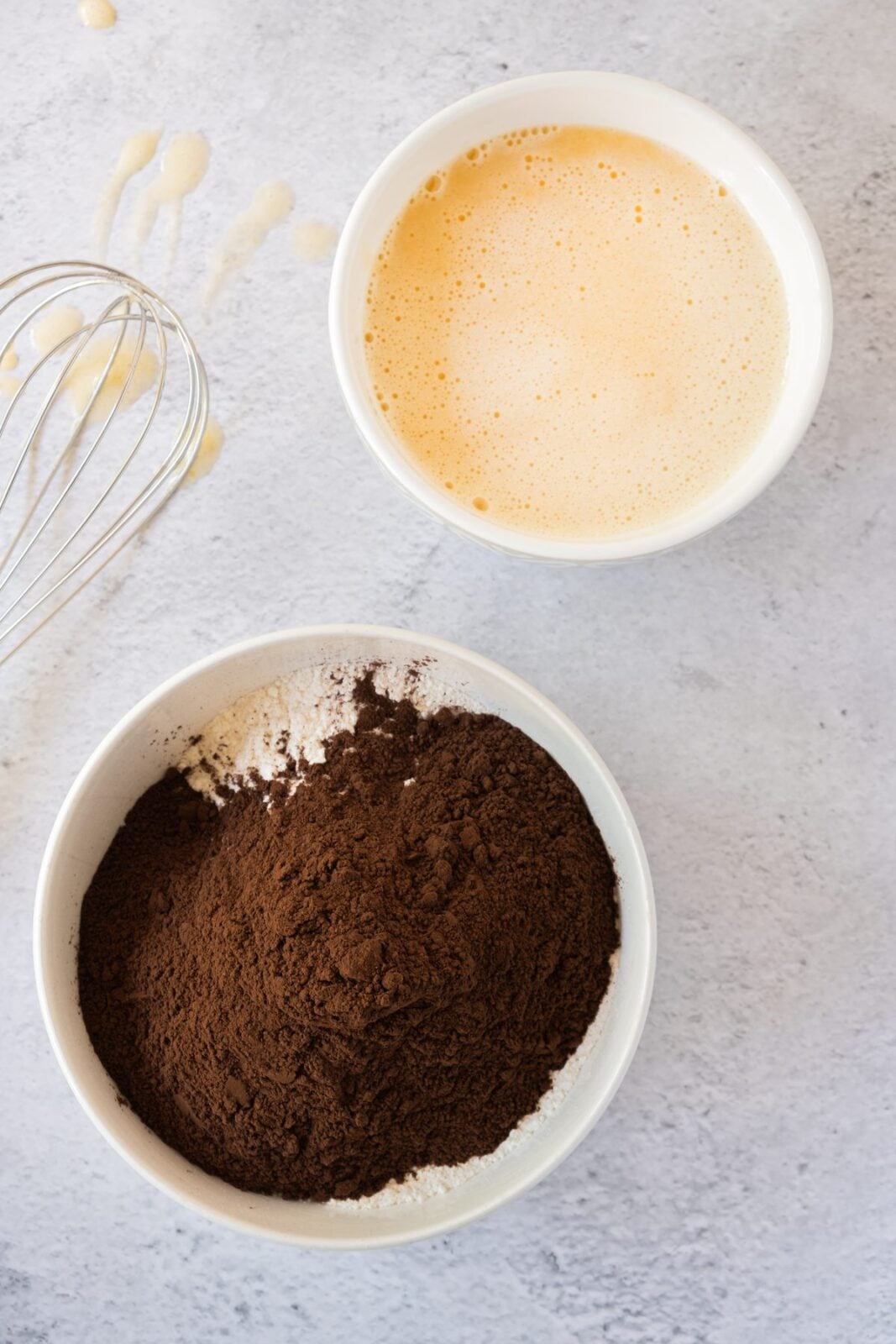 Bowl of sifted cocoa and flour next to the beaten egg mixture