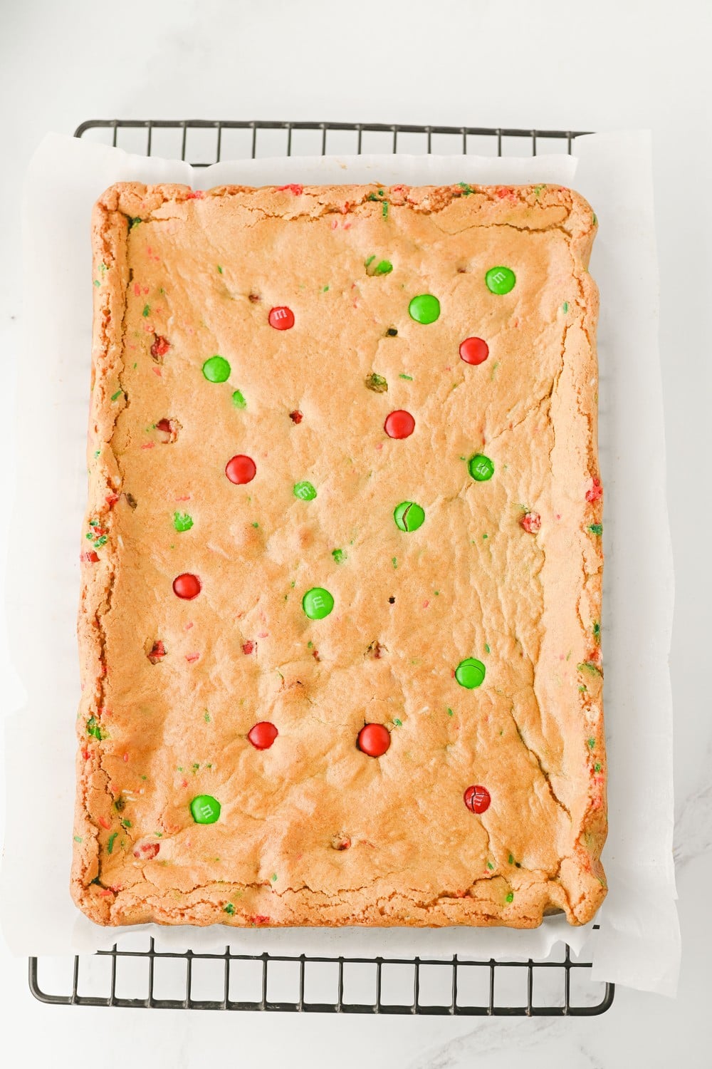 Baked Christmas cookie bar slab cooling on a wire rack