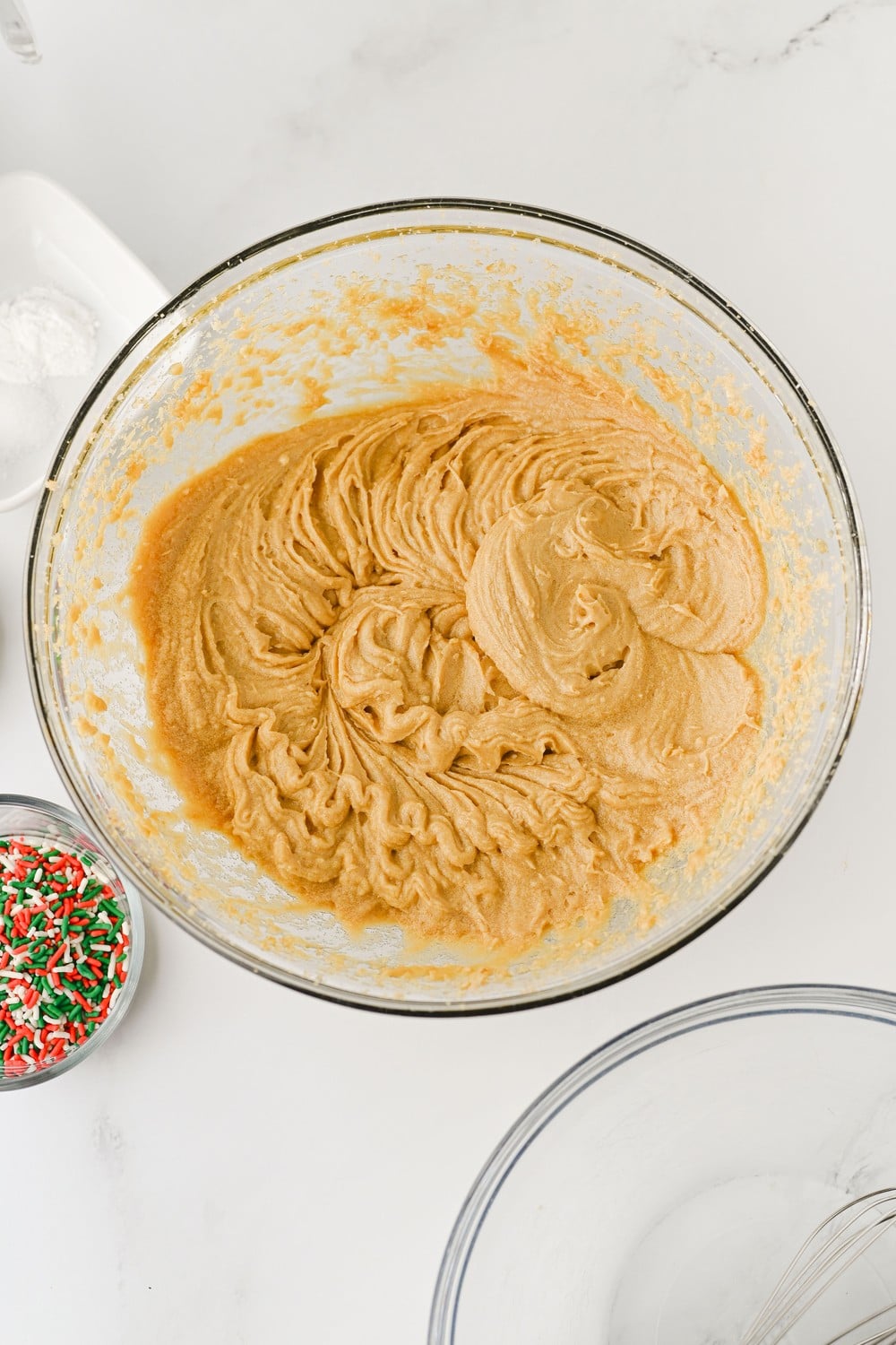 Butter and brown sugar creamed together in a glass mixing bowl