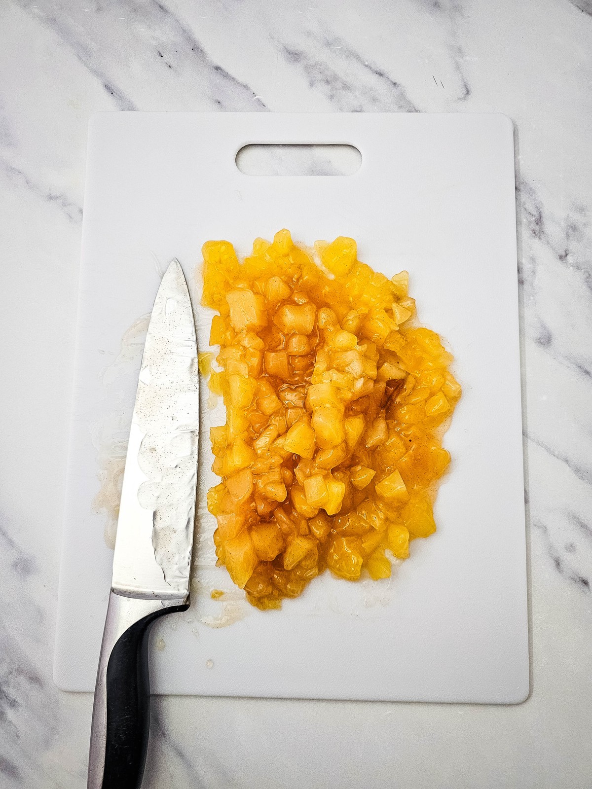 Apple pie filling chopped into small pieces on a cutting board