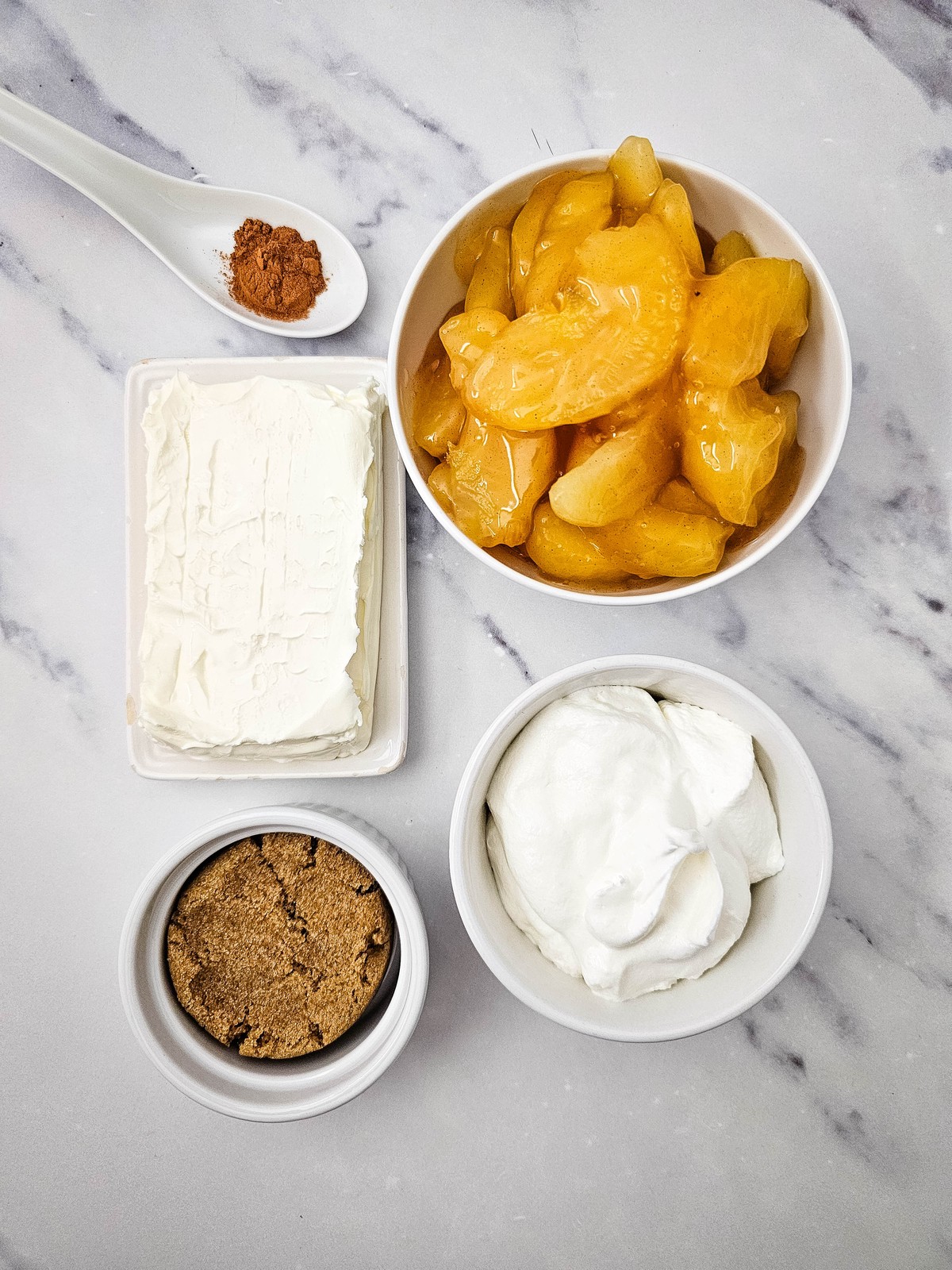 Five ingredients for creamy apple pie dip: cream cheese, brown sugar, whipped topping, apple pie filling and cinnamon