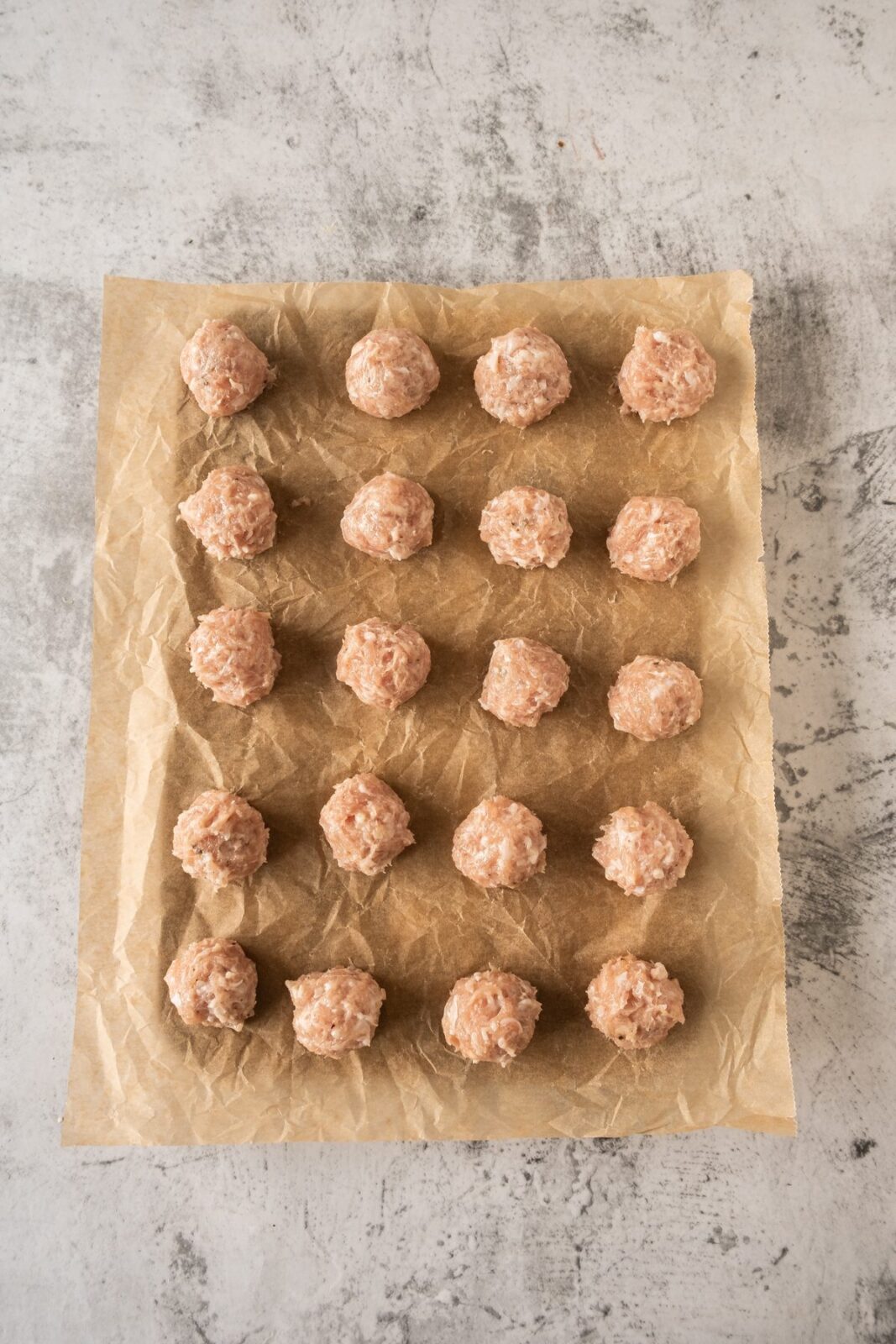 Chicken wrapped garlic butter balls arranged on a parchment lined tray