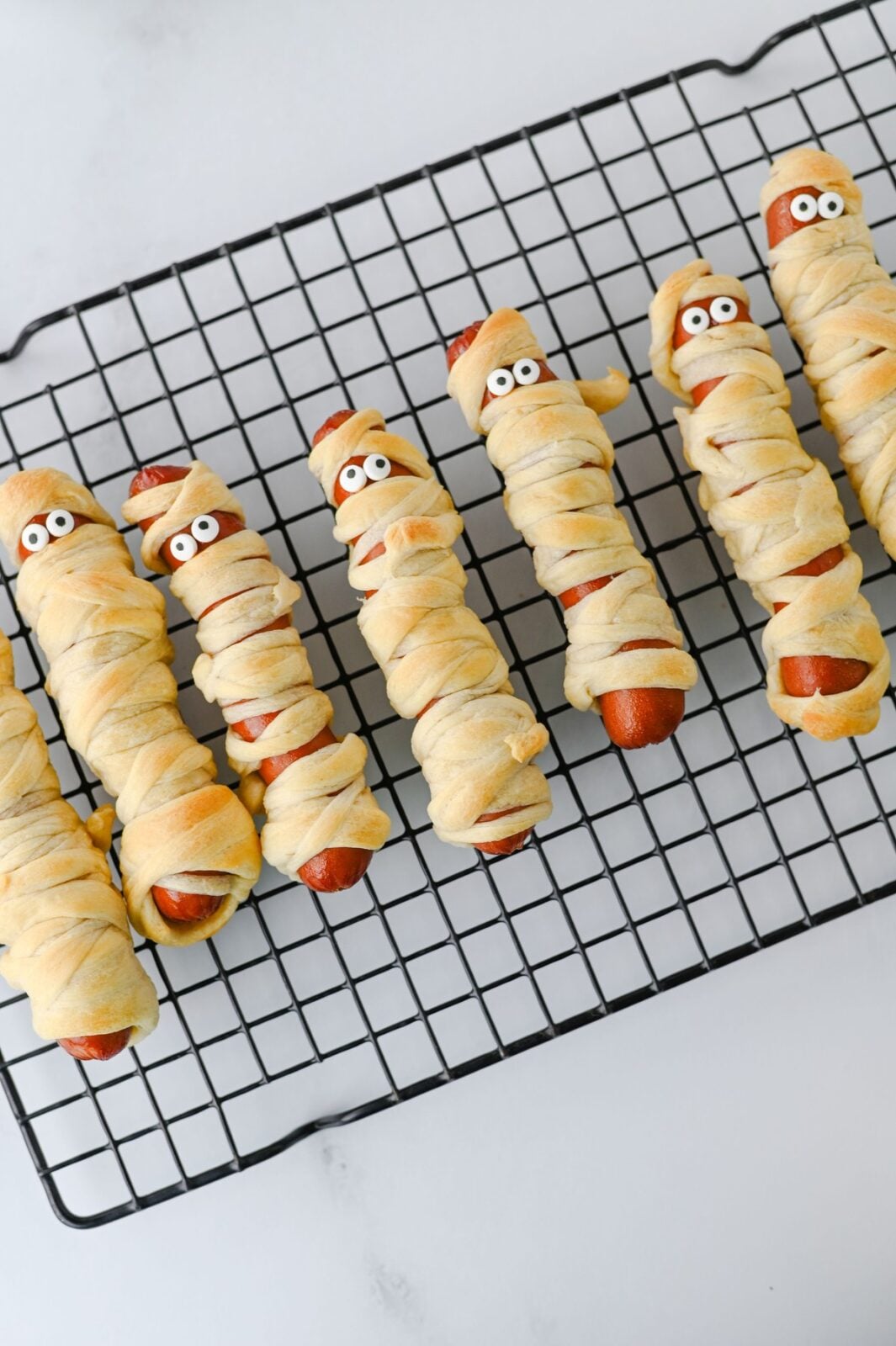 Baked mummy hot dogs with candy eyes attached
