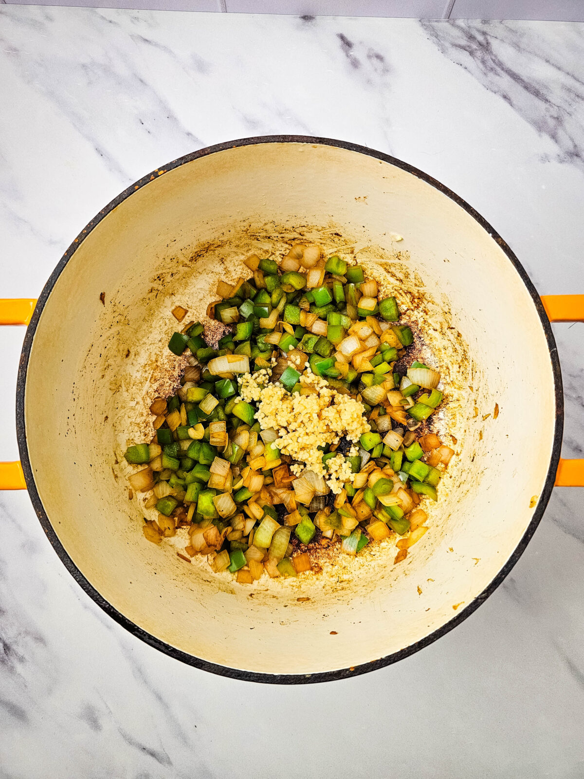 Minced garlic added to sauteed onion and bell pepper