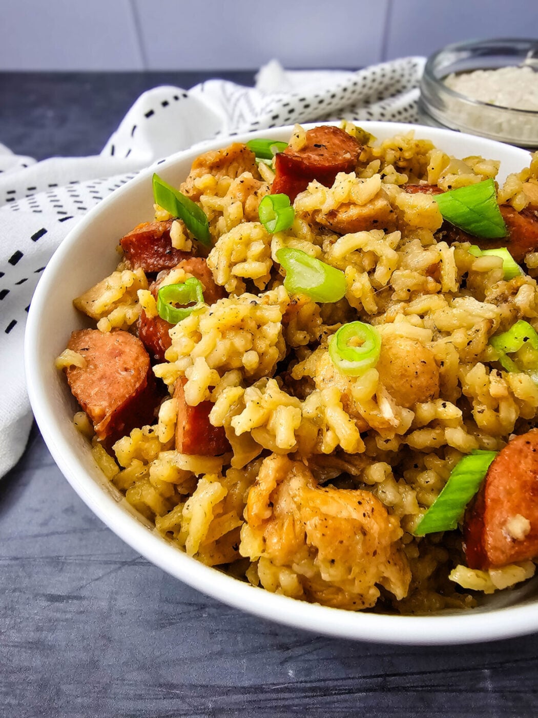 Bowl of one pot jambalaya with chicken, sausage, rice, and green onion