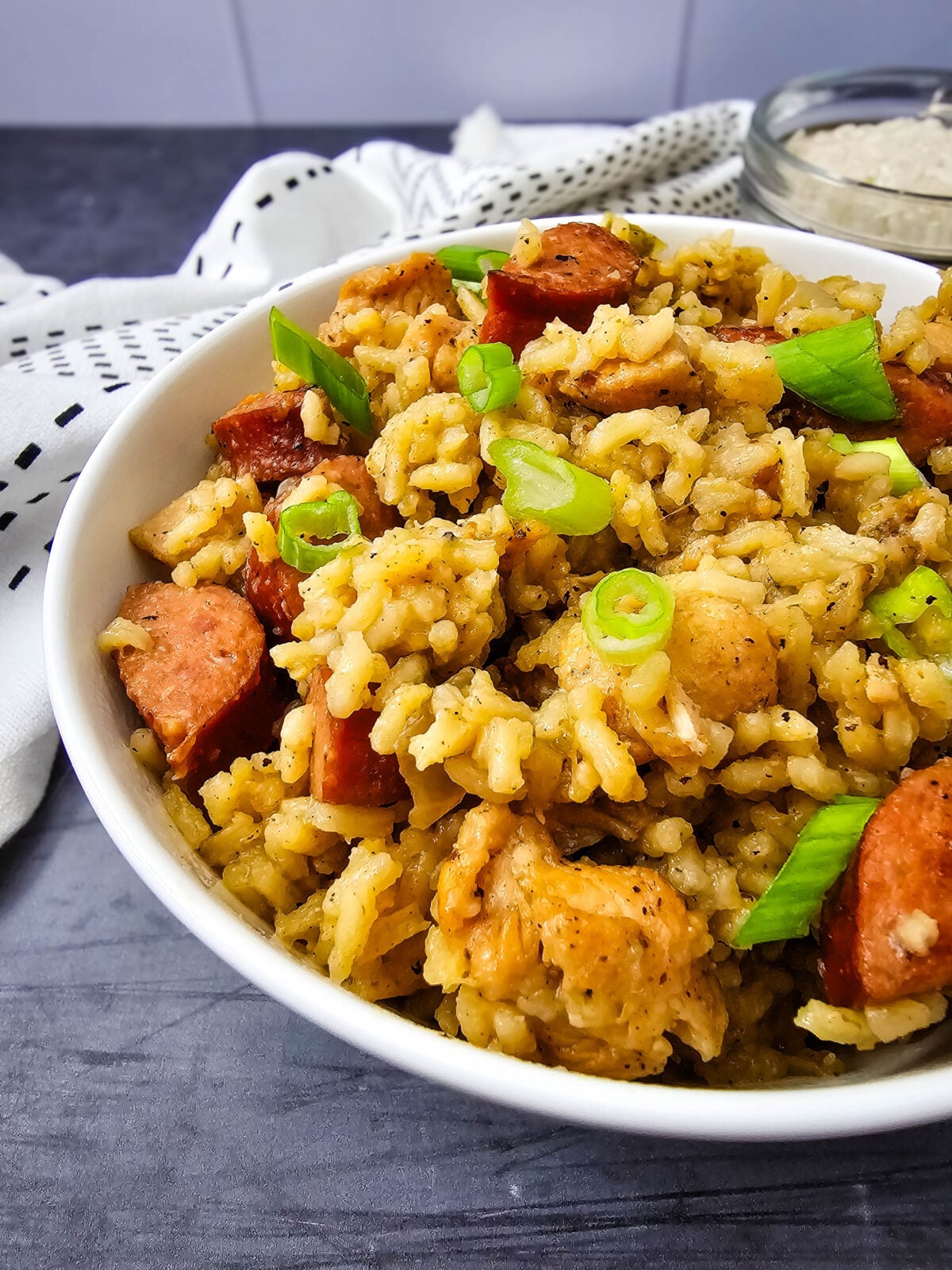 Bowl of one pot jambalaya with chicken, sausage, rice, and green onion