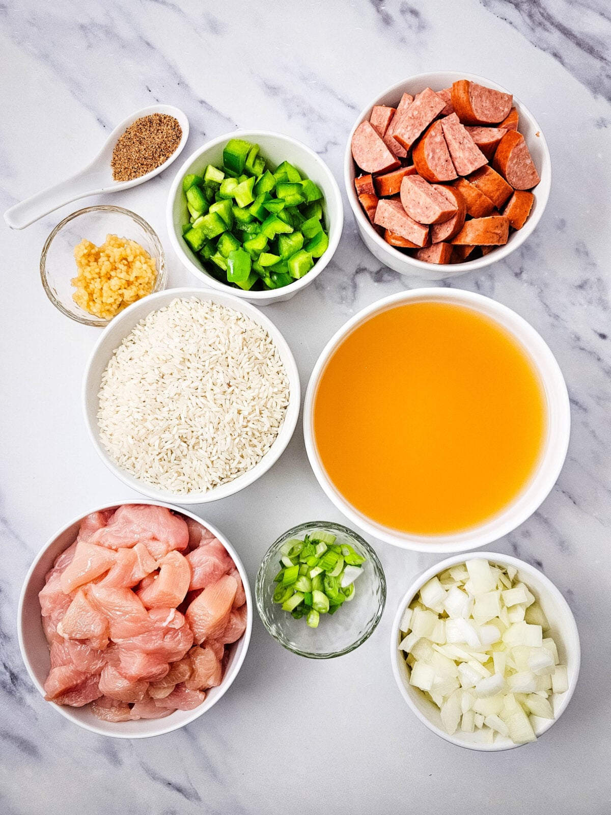 Chicken, sausage, rice, and vegetables measured out for one pot jambalaya