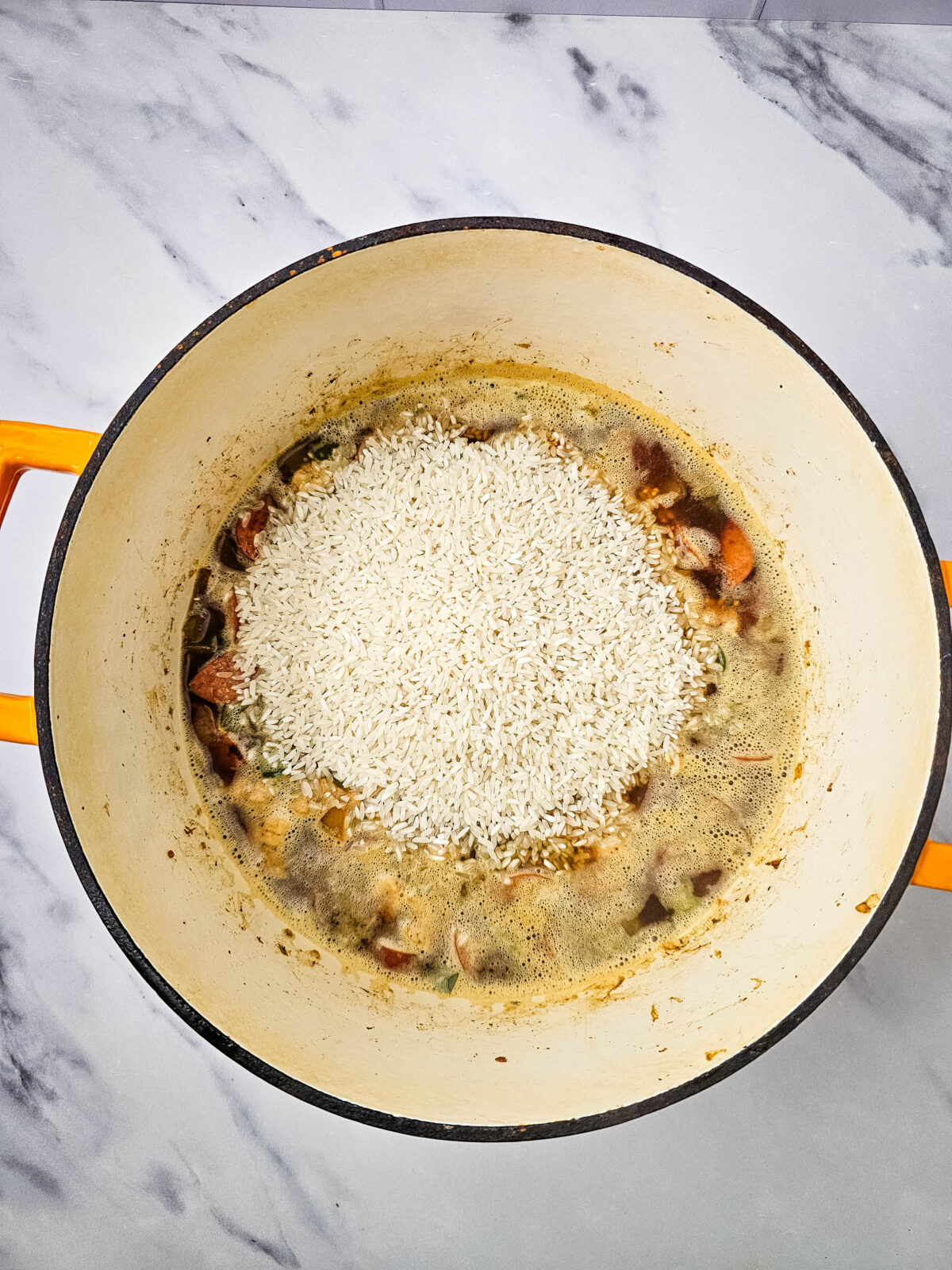 Rice stirred into the pot of jambalaya