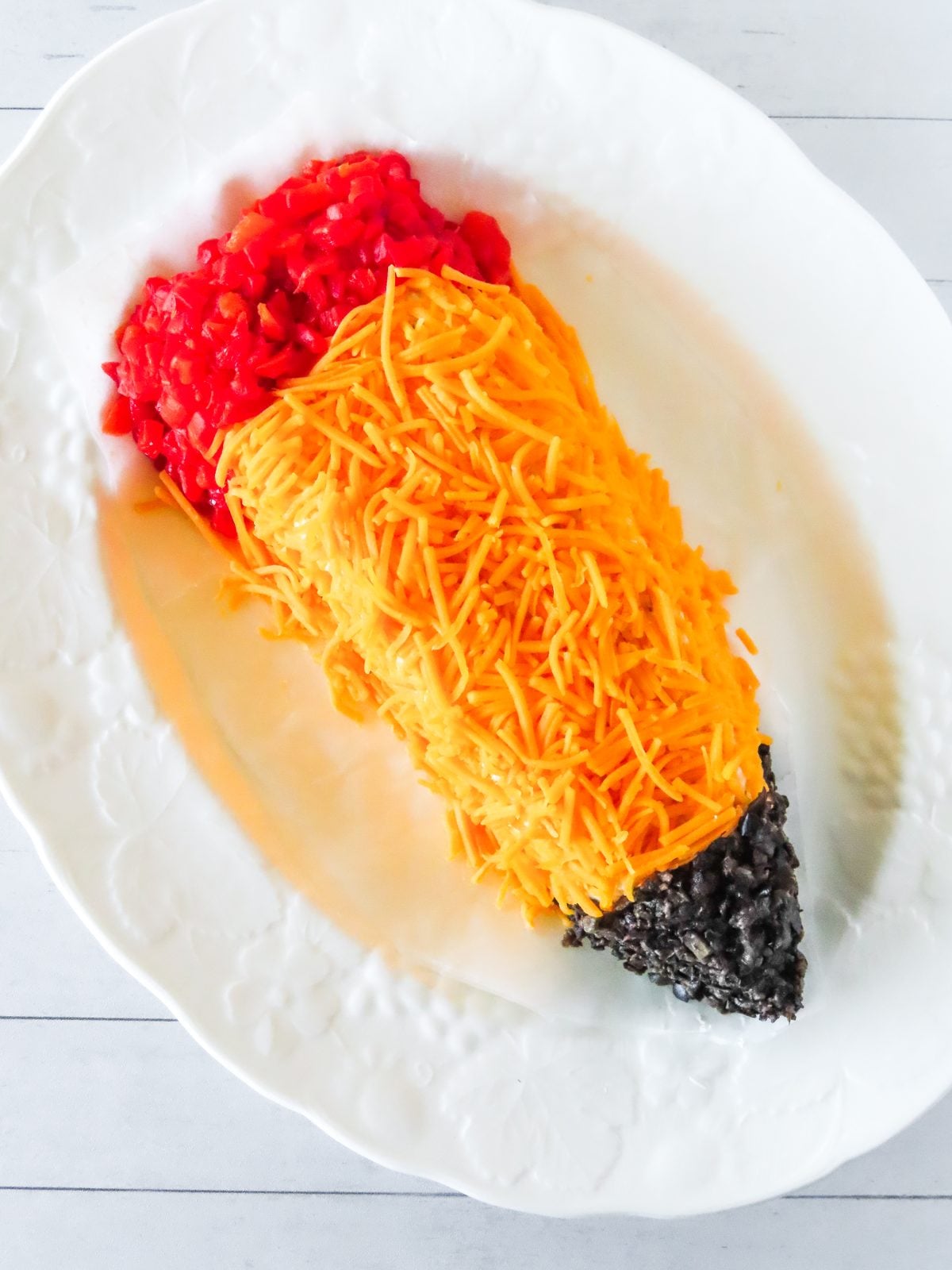 Pencil cheese ball with shredded cheddar shaft and diced pimiento eraser