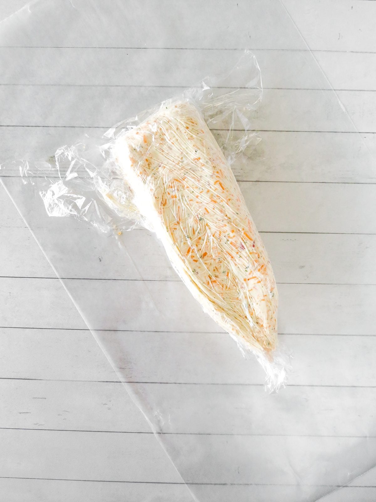 Cheese ball mixture wrapped in plastic wrap