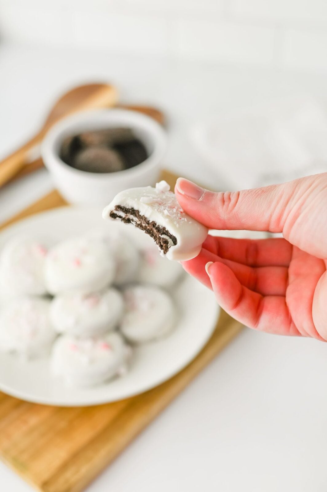 Peppermint crunch Oreo with a bite taken out showing the chocolate cookie inside