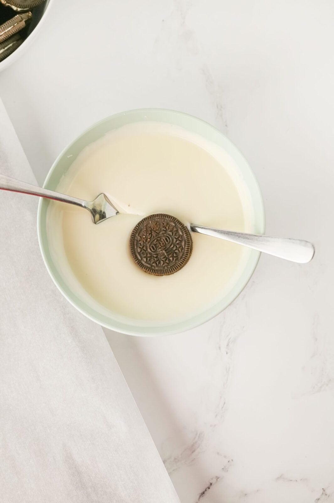 Dipping an Oreo cookie into melted vanilla almond bark