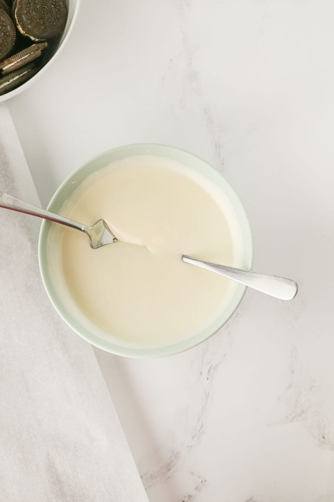 Melted vanilla almond bark in a bowl with a fork