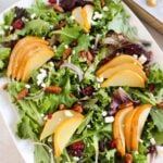 Assembled roasted pear salad on an oval platter with warm pear slices