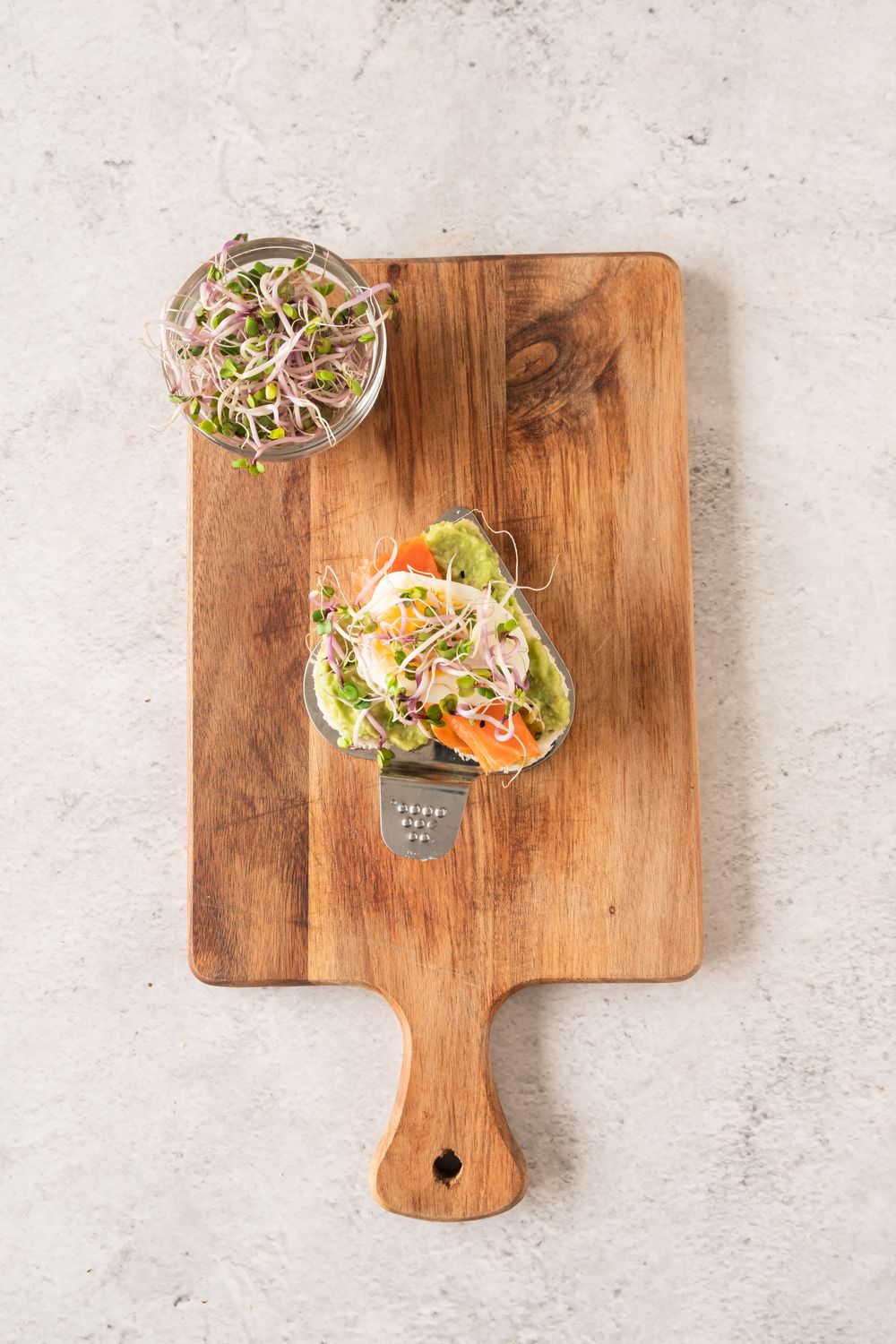 Assembled tea sandwich topped with boiled egg and radish sprouts