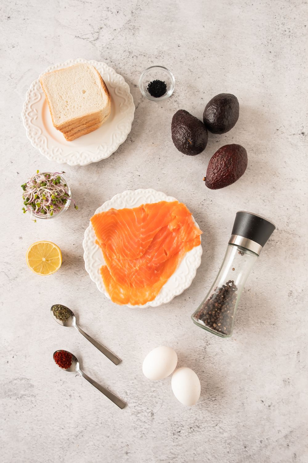 Smoked salmon avocado tea sandwiches ingredients laid out on a marble surface