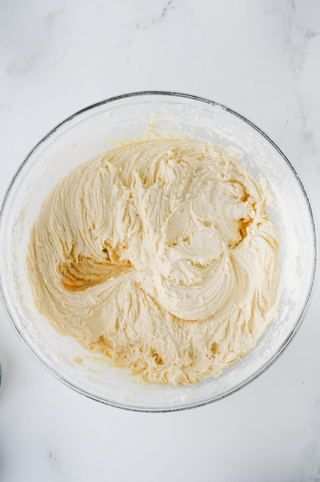 Finished sugar cookie bar dough in a glass mixing bowl