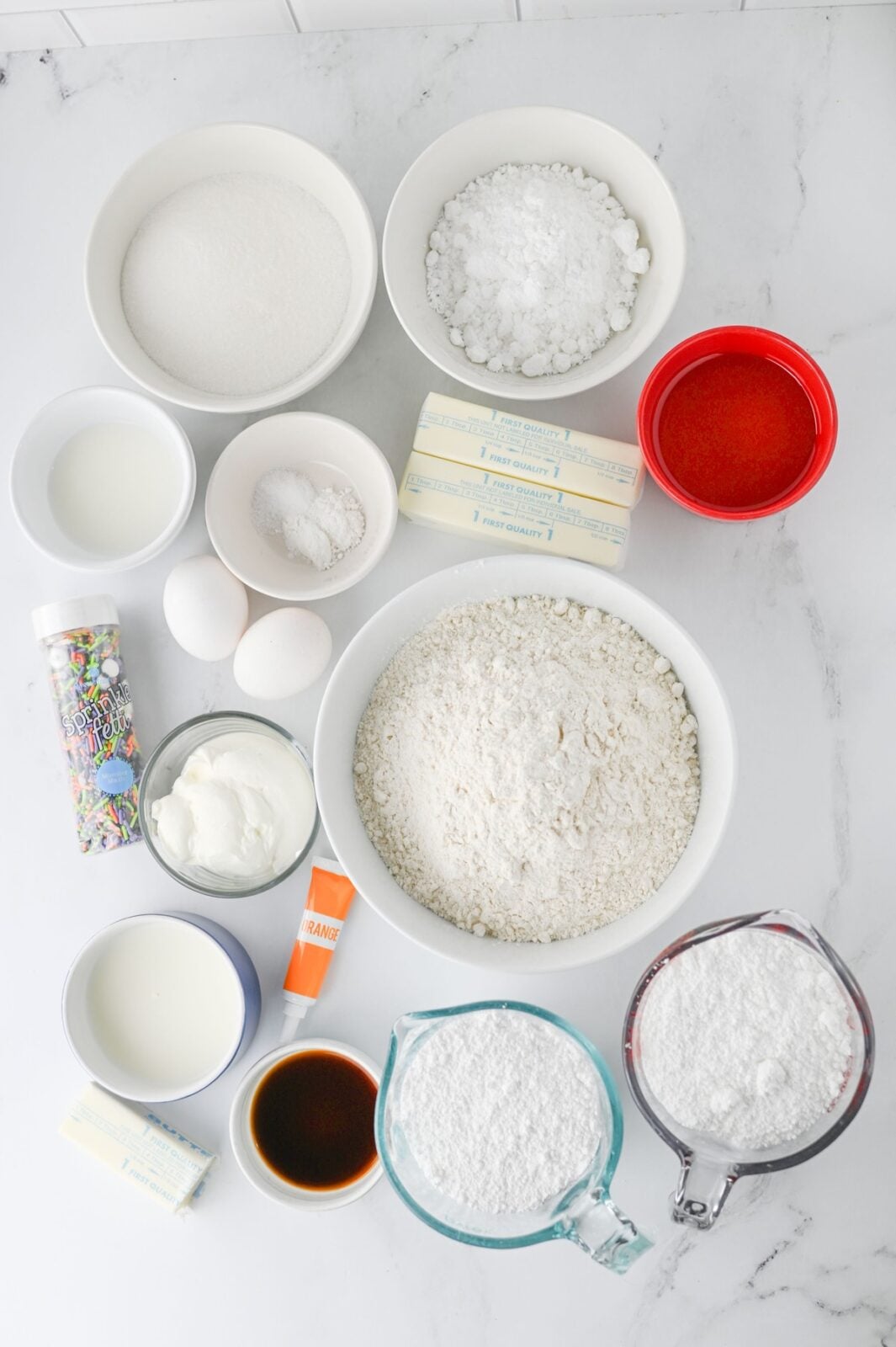 Ingredients for Halloween sugar cookie bars laid out on a marble counter