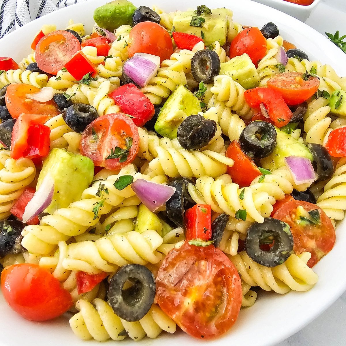 Overhead view of vegan pasta salad loaded with fresh vegetables and herbs