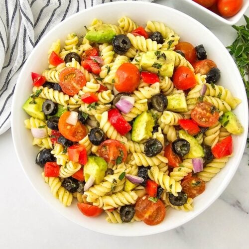Vegan pasta salad garnished with fresh herbs, ready to serve