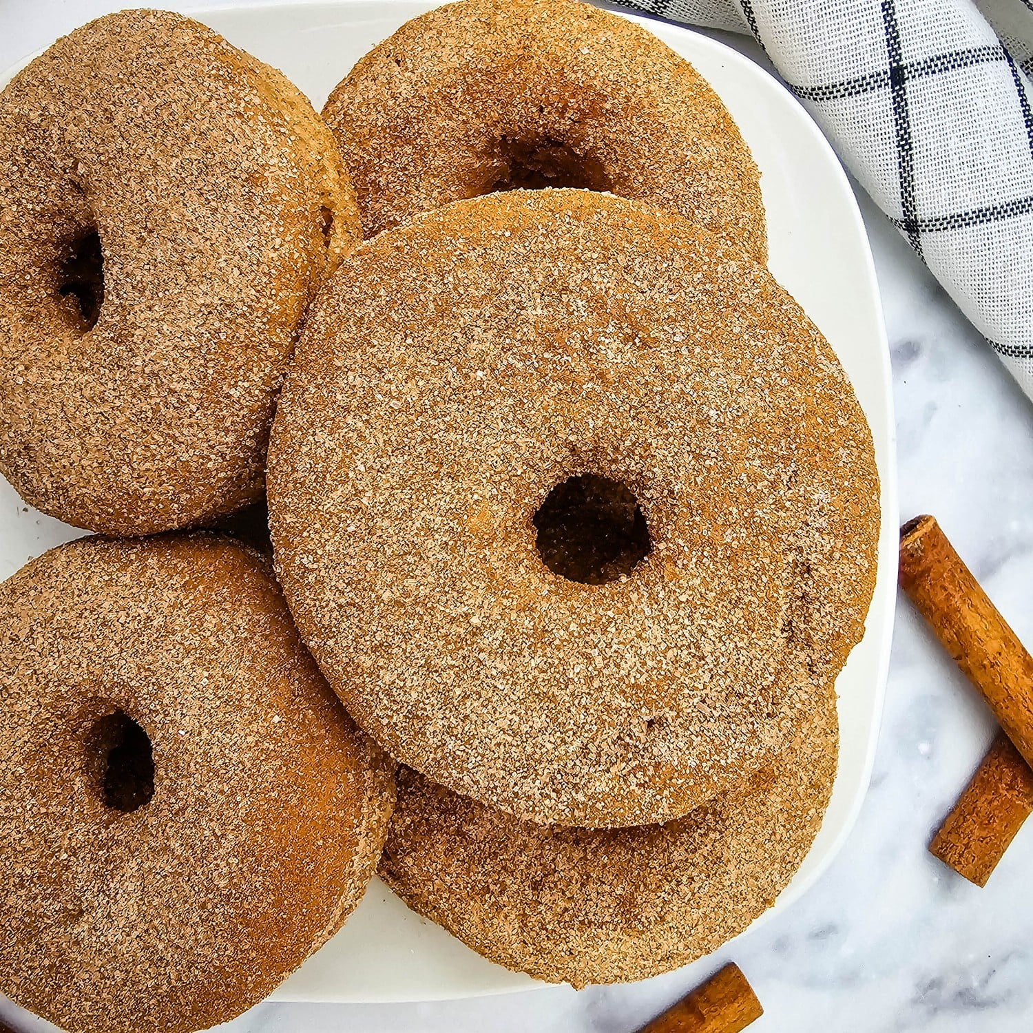 Close up of baked apple cider donuts coated in cinnamon sugar