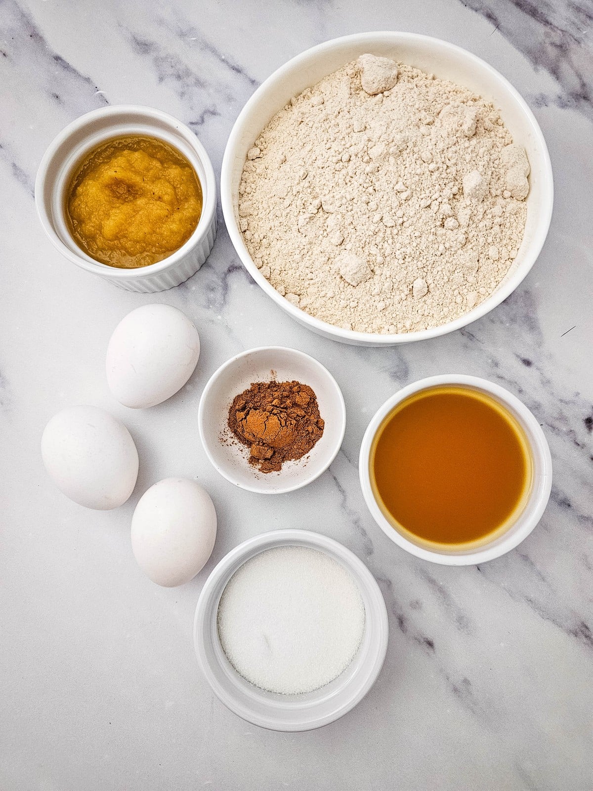 Apple cider donuts ingredients flat lay with spice cake mix, applesauce, apple cider, eggs, sugar and cinnamon