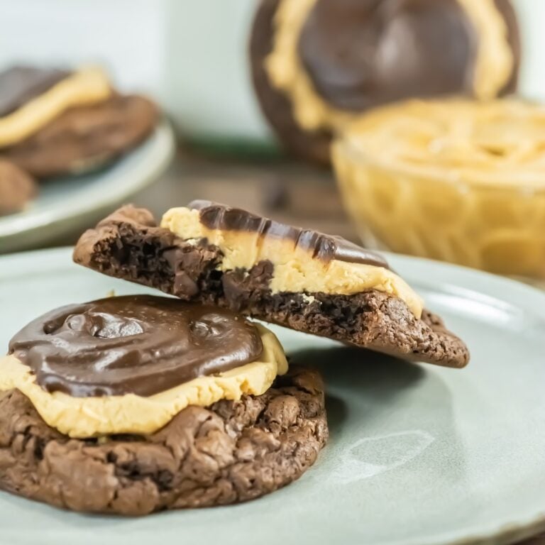 Crumbl copycat buckeye brownie cookie broken in half showing fudgy layers of peanut butter and ganache