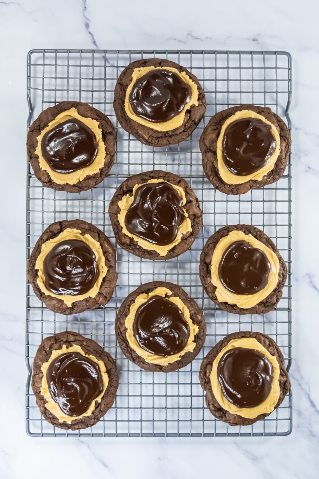 Buckeye brownie cookies topped with peanut butter filling and chocolate ganache