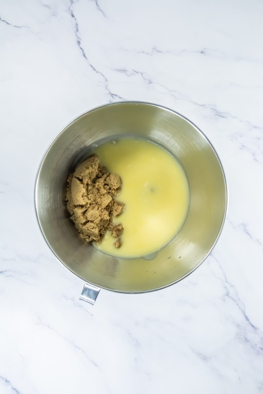 Brown sugar, granulated sugar, and melted butter in a stand mixer bowl