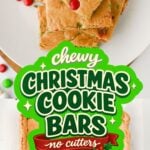 A full pan of chewy Christmas cookie bars dotted with red and green holiday candies