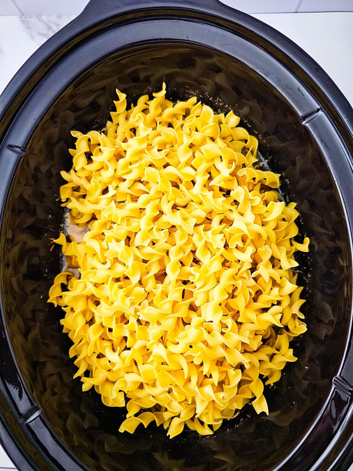 wide egg noodles added to the crockpot at the end of cooking