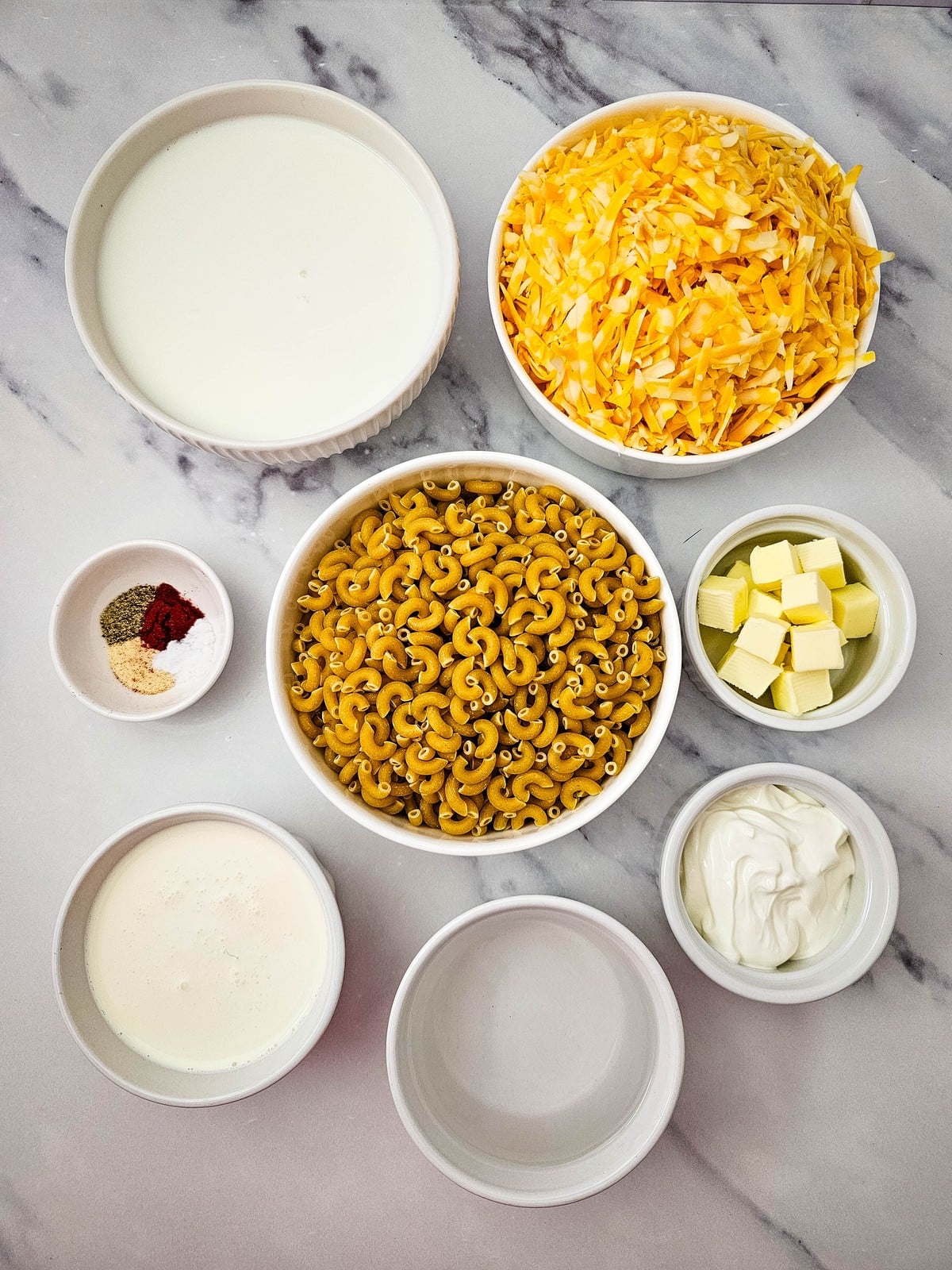 Ingredients for crockpot mac and cheese in white bowls