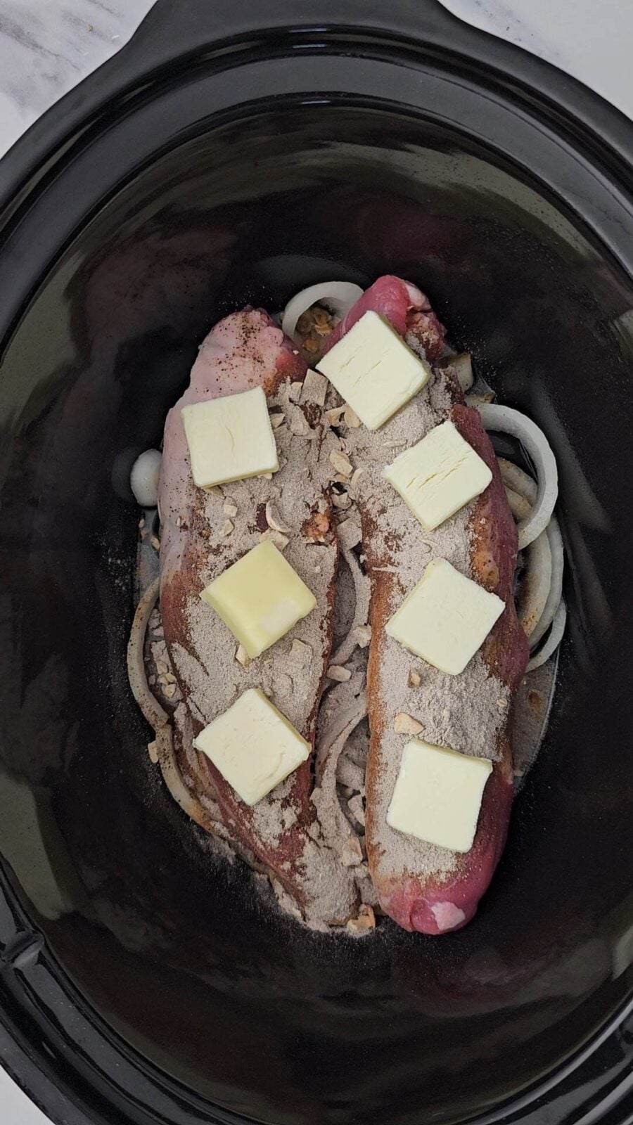pats of sliced butter arranged over the gravy mix