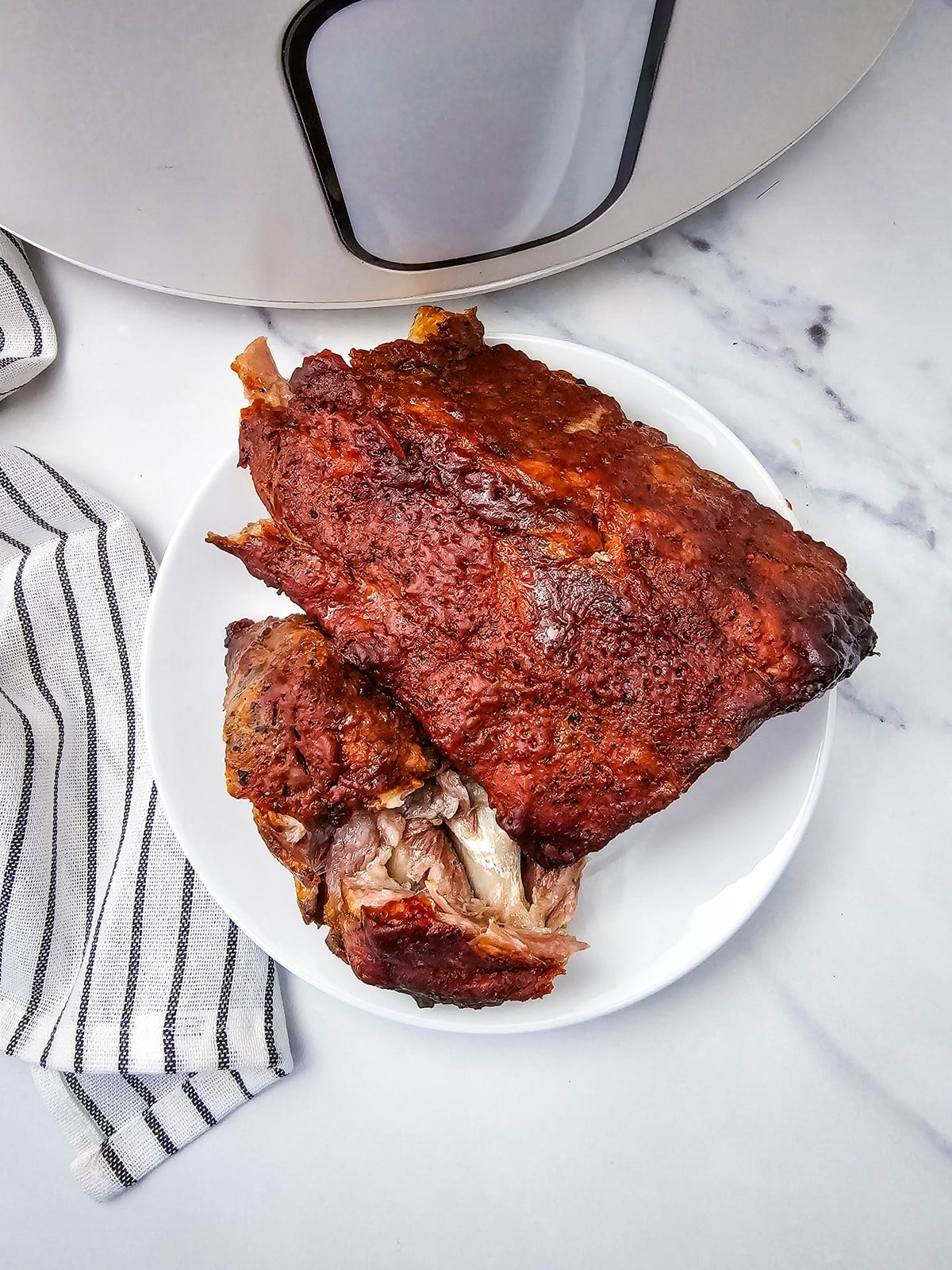 Fall off the bone crockpot ribs on a white plate