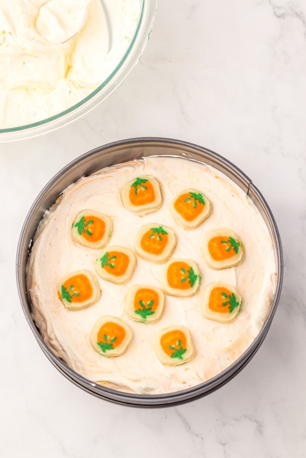 Cookie dough pieces layered over cheesecake filling in a springform pan