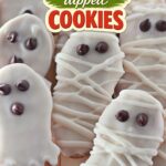 White chocolate dipped cookies shaped like ghosts and mummies with chocolate chip eyes