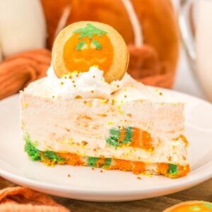 Slice of no bake Halloween cheesecake with a pumpkin cookie on top