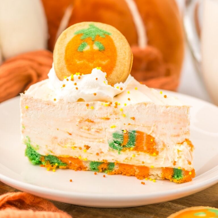 Slice of no bake Halloween cheesecake with a pumpkin cookie on top
