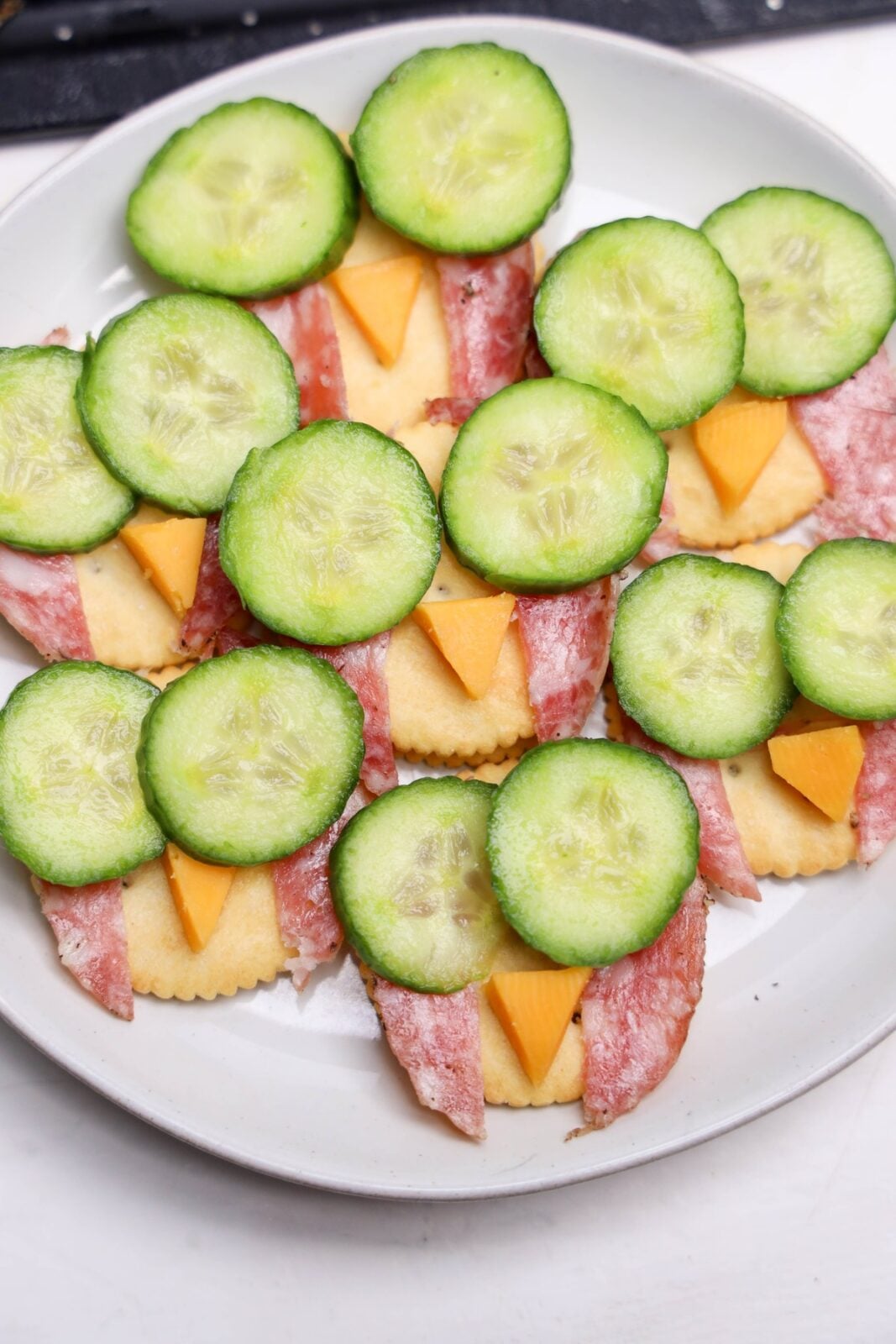 Cheddar triangles added under the cucumber rounds as owl beaks