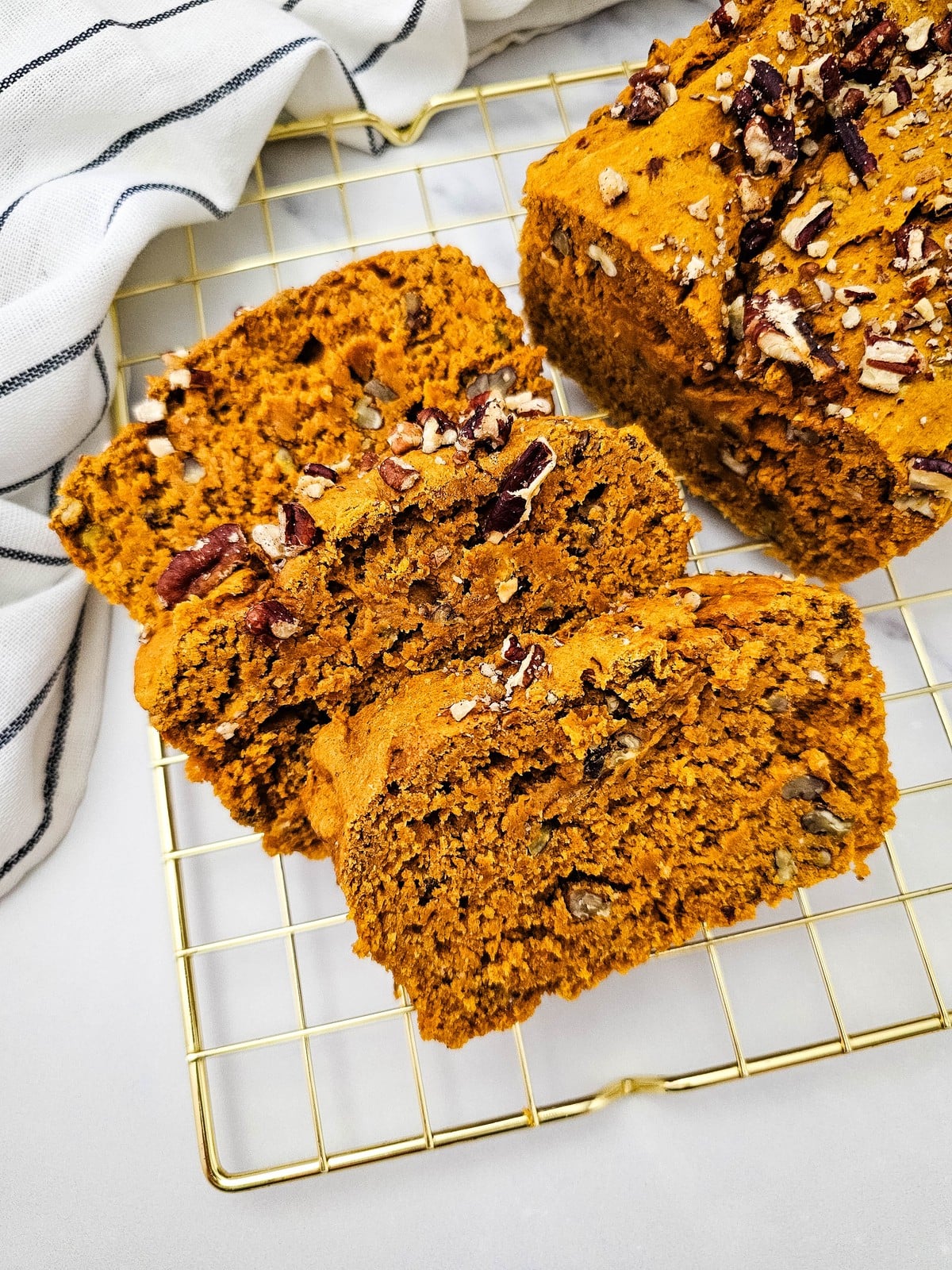 Close up of pumpkin bread slices showing the moist crumb and pecan pieces