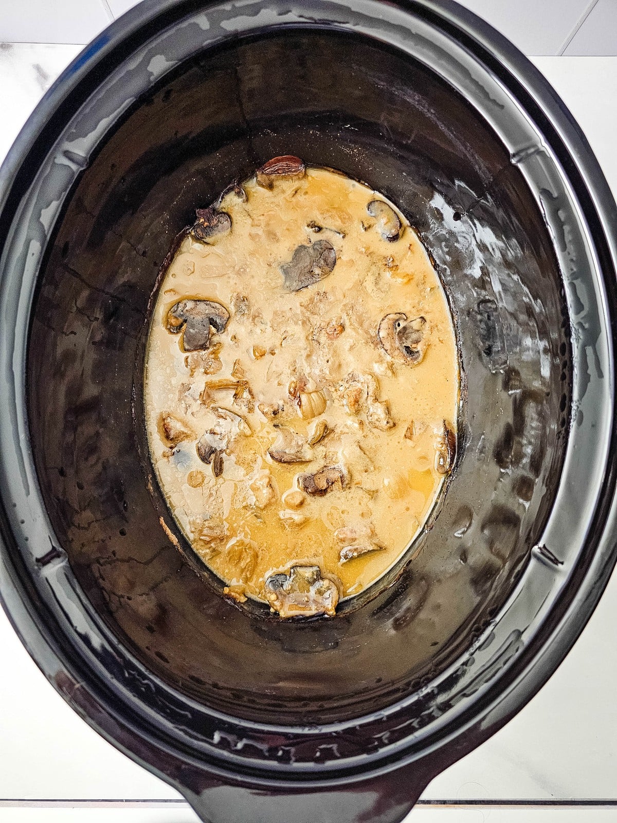 Cooked beef stroganoff sauce with tender mushrooms in the slow cooker after eight hours on low