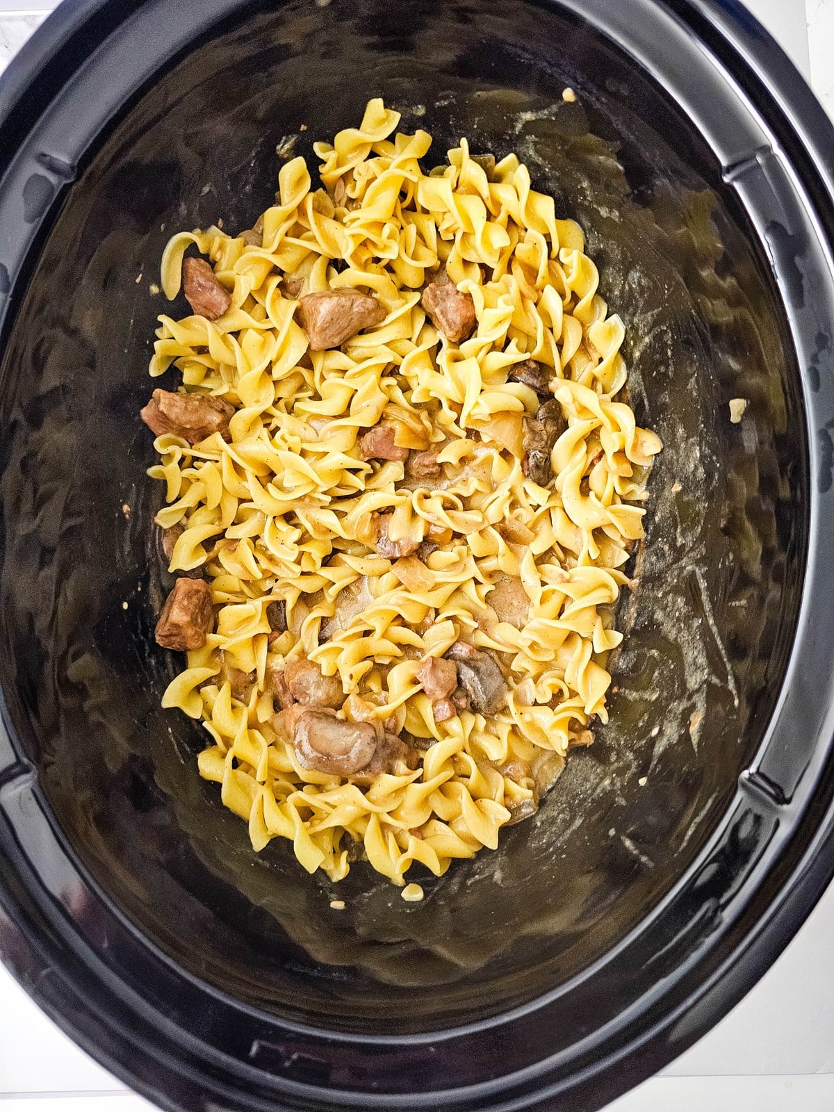 Egg noodles stirred through the beef stroganoff sauce with visible chunks of beef