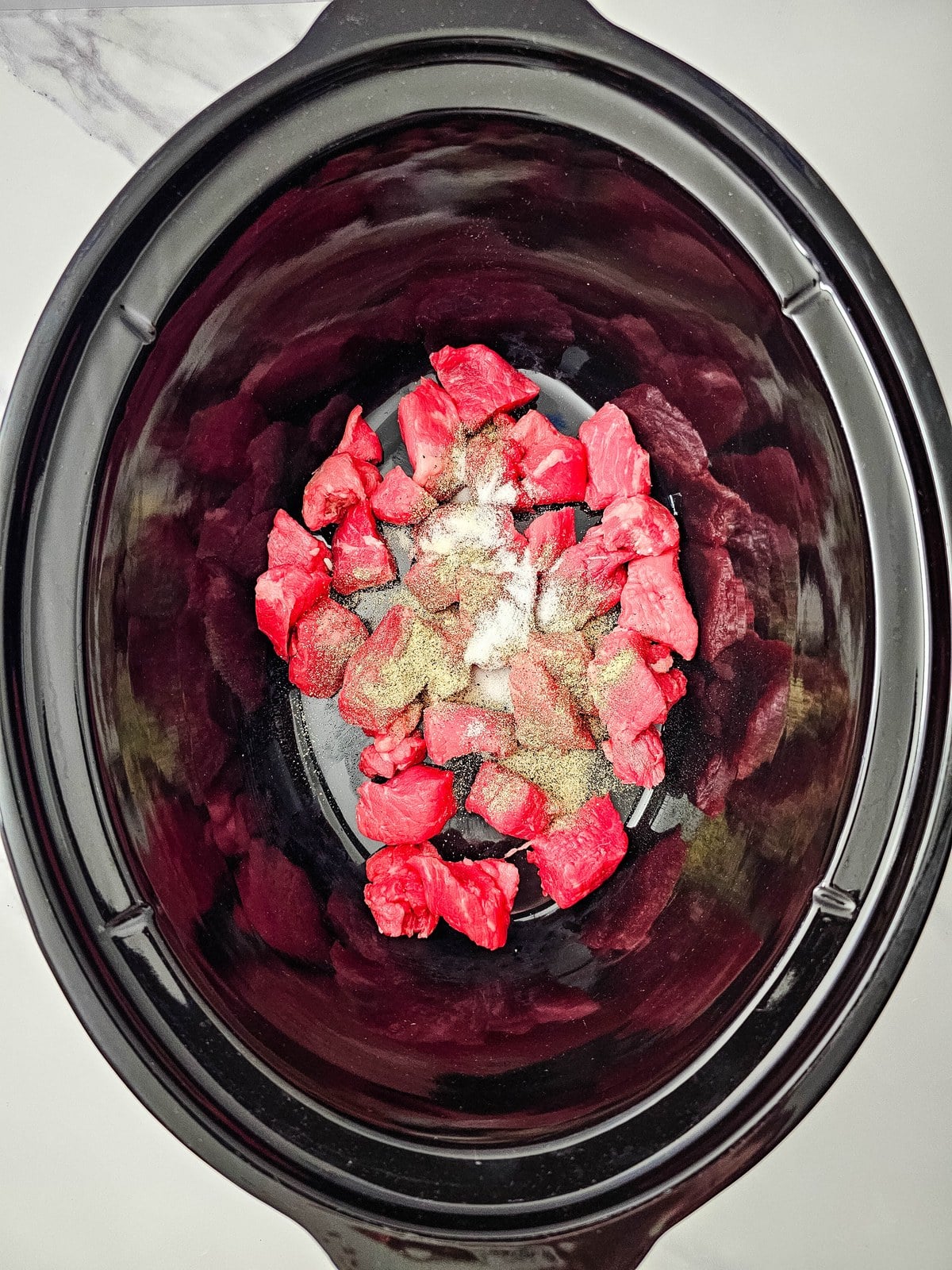 Salt and pepper sprinkled over the stew meat in the crockpot