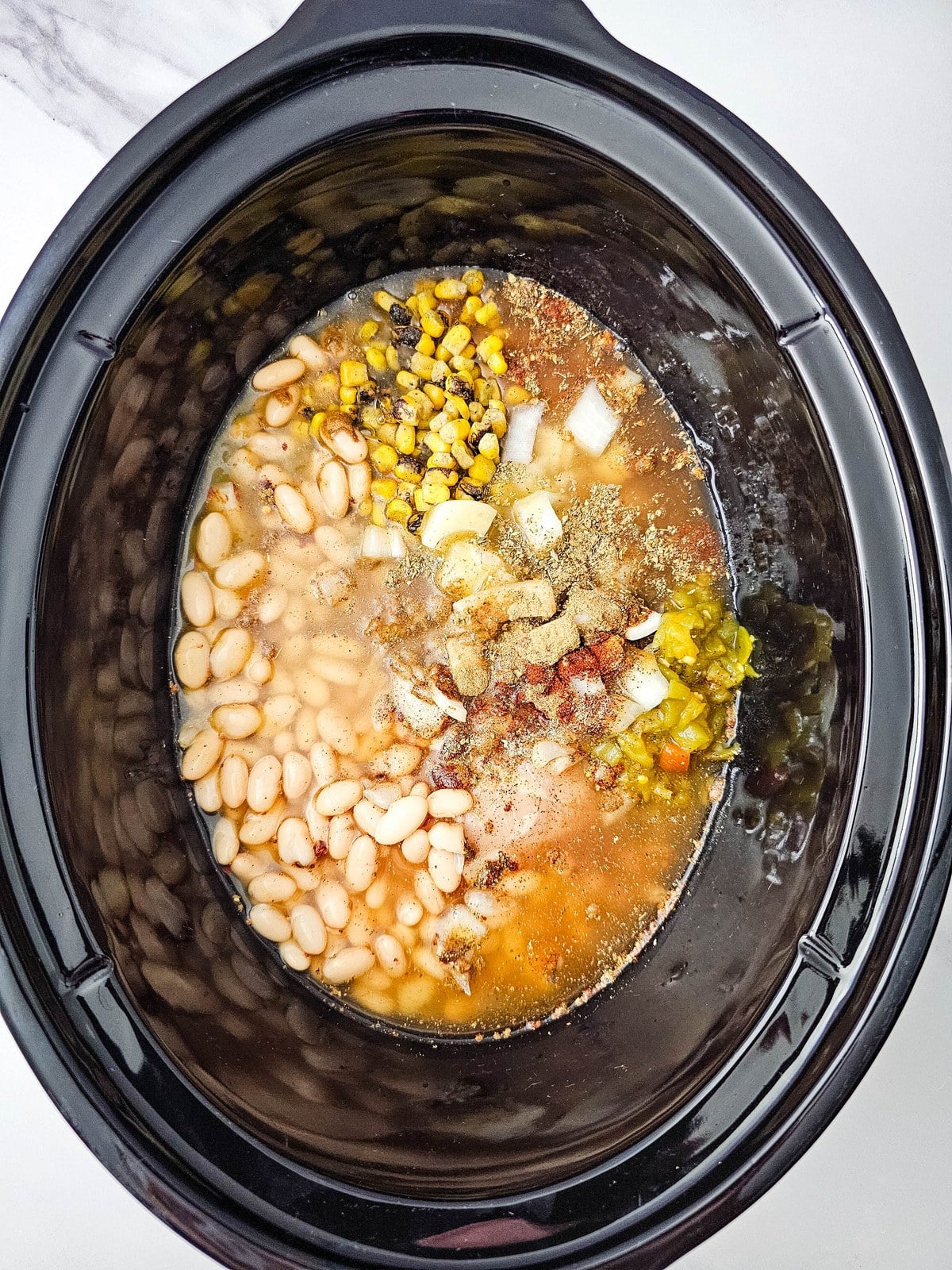 Chicken broth poured into the crockpot until the ingredients are covered