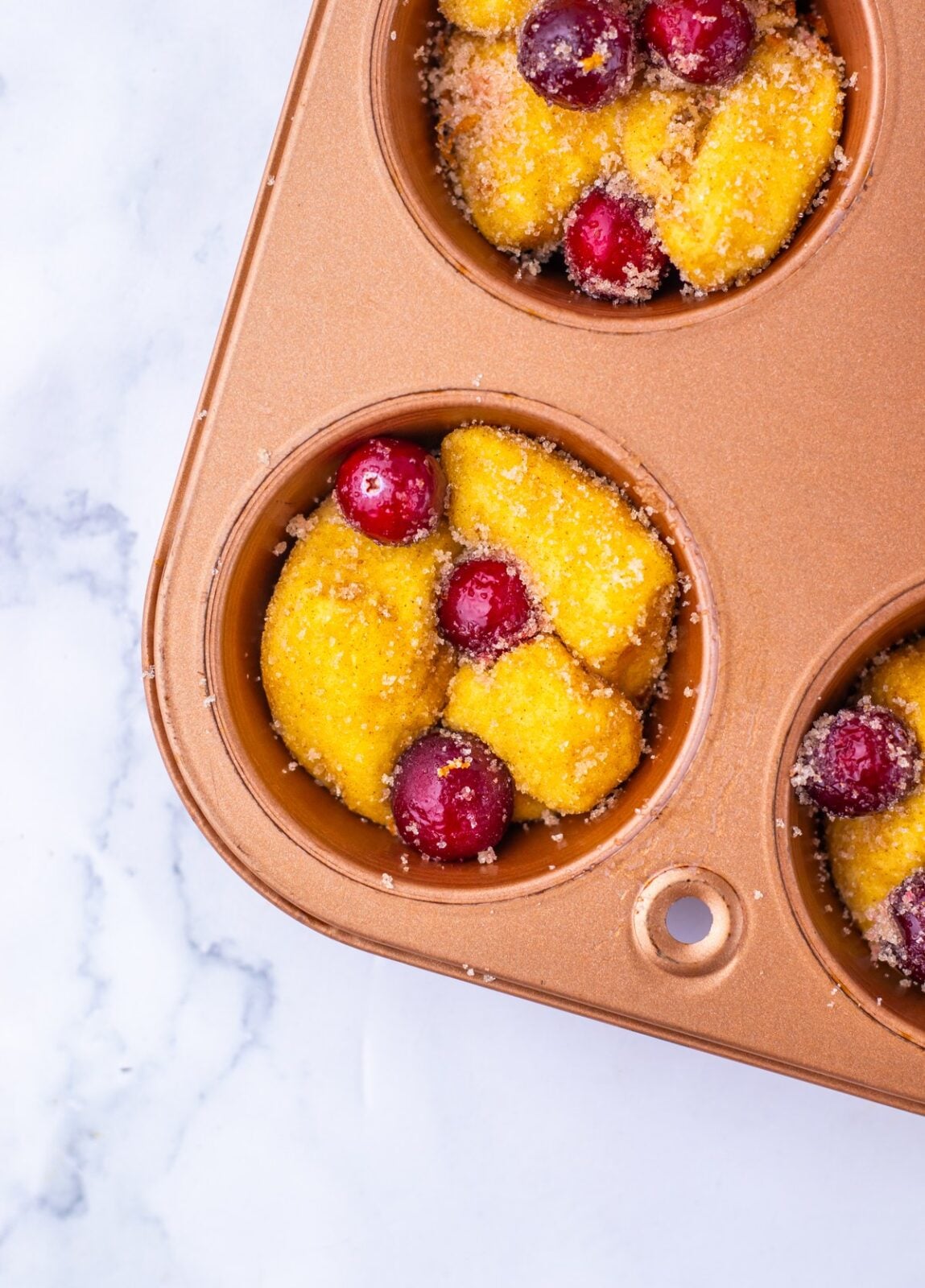 Cranberry Orange Monkey Bread Bites process: divide the biscuit and cranberry mixture between the muffin cups, filling each one nearly to the top