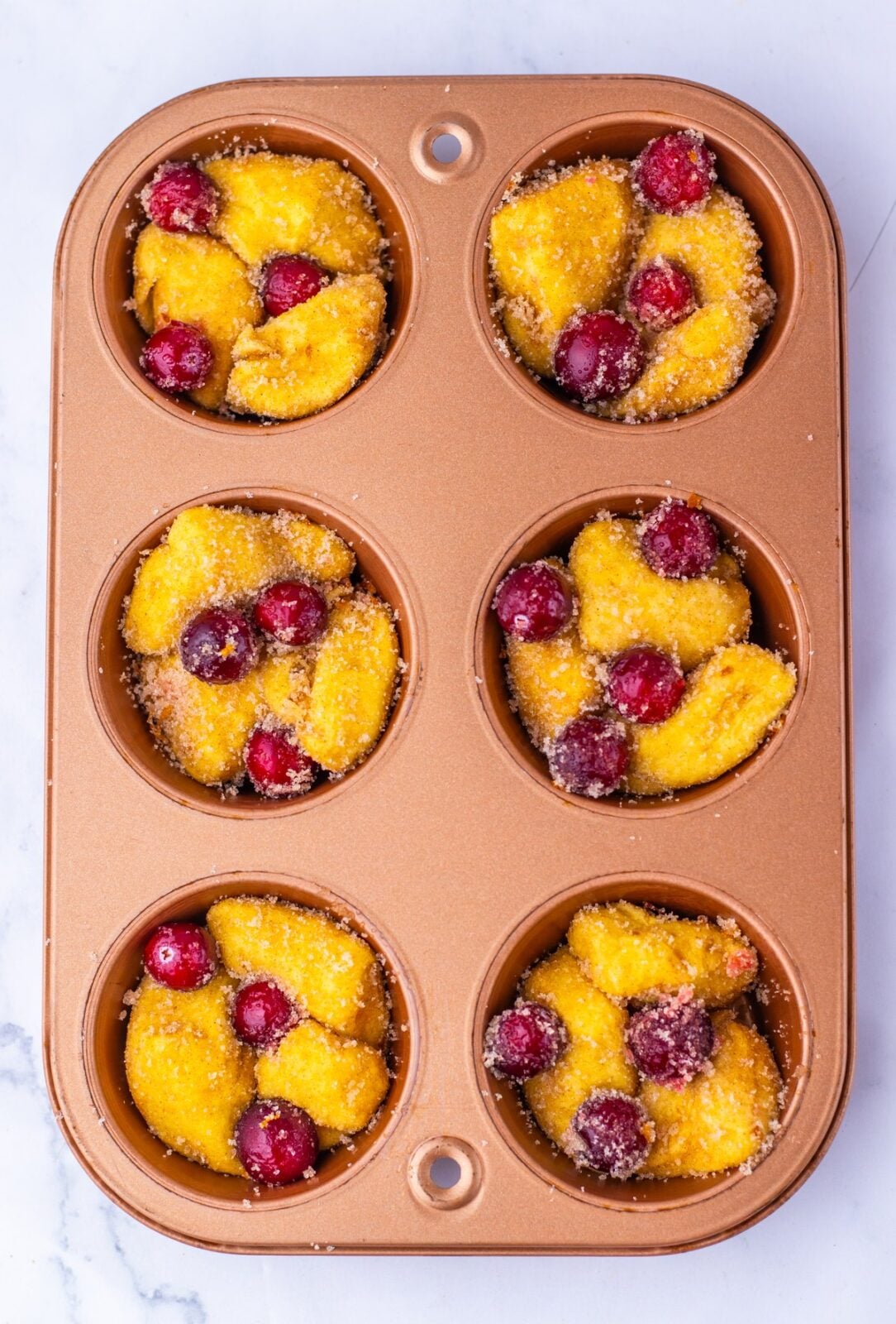 Cranberry Orange Monkey Bread Bites process: divide the biscuit and cranberry mixture between the muffin cups, filling each one nearly to the top